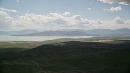 5.5K aerial stock footage of flying by farmland, distant mountain range and Utah Lake, Utah Aerial Stock Footage | AX130_080E