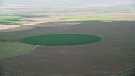 5.5K aerial stock footage of flying by green circular crop field, Elberta, Utah Aerial Stock Footage | AX130_084E