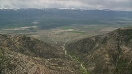 5.5K aerial stock footage approaching a valley from between two mountain peaks, Wasatch Range, Utah Aerial Stock Footage | AX130_135