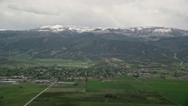 5.5K aerial stock footage of passing small rural town, Wasatch Range in the background, Ephraim, Utah Aerial Stock Footage | AX130_138E