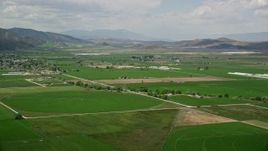 5.5K aerial stock footage of approaching farmland, distant mountain ranges, Manti, Utah Aerial Stock Footage | AX130_143E