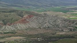5.5K aerial stock footage of flying by rugged hills, farmland in background, Sterling, Utah Aerial Stock Footage | AX130_158E