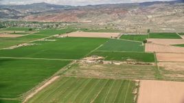 5.5K aerial stock footage of lying by farmhouse and green fields, Richfield, Utah Aerial Stock Footage | AX130_192E