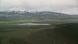 5.5K aerial stock footage of Koosharem Reservoir, snowy mountains, Fishlake National Forest, Utah Aerial Stock Footage | AX130_209E