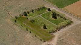 5.5K aerial stock footage of orbiting a tiny cemetery by rural road, dirt fields, Bicknell, Utah Aerial Stock Footage | AX130_239