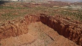 5.5K aerial stock footage of flying by a box canyon, mesas topped with trees, Capitol Reef National Park, Utah Aerial Stock Footage | AX130_256