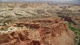 5.5K aerial stock footage of flying by Waterpocket fold rock formations, desert road through a canyon, Capitol Reef National Park, Utah Aerial Stock Footage | AX130_266E