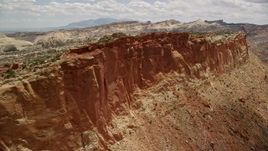 5.5K aerial stock footage of a rugged mesa cliff near Waterpocket Fold rock formations, Capitol Reef National Park, Utah Aerial Stock Footage | AX130_270E