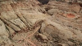 5.5K aerial stock footage fly over dirt road, tilt to reveal Waterpocket Fold rock formations, Capitol Reef National Park, Utah Aerial Stock Footage | AX130_276