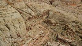 5.5K aerial stock footage fly over dirt road, tilt to reveal Waterpocket Fold rock formations, Capitol Reef National Park, Utah Aerial Stock Footage | AX130_276E