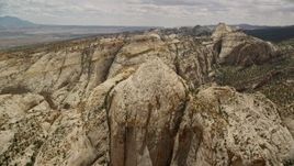 5.5K aerial stock footage of approaching the Waterpocket Fold rock formations, pan to canyon, Capitol Reef National Park, Utah Aerial Stock Footage | AX130_315E