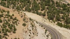 5.5K aerial stock footage of a bend in Route 12, reveal and track a black SUV, Boulder, Utah Aerial Stock Footage | AX130_374E