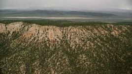 5.5K aerial stock footage of flying by mountain ridge, trees, dry lake in the distance, Bryce Canyon National Park, Utah Aerial Stock Footage | AX130_420E