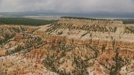 5.5K aerial stock footage of passing by groups of hoodoos around base of mesa, Bryce Canyon National Park, Utah Aerial Stock Footage | AX130_430E