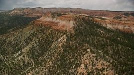 5.5K aerial stock footage of flying by small mesa with hoodoos, trees, desert vegetation at Bryce Canyon National Park, Utah Aerial Stock Footage | AX130_451E