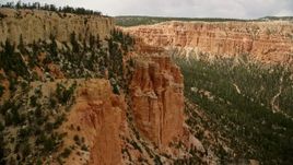 5.5K aerial stock footage of passing by hoodoos overlooking box canyon between mesas, Bryce Canyon National Park, Utah Aerial Stock Footage | AX130_466E