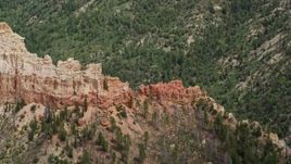 5.5K aerial stock footage of flying by jagged butte, revealing forested valley, Bryce Canyon National Park, Utah Aerial Stock Footage | AX131_016