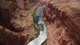 5.5K aerial stock footage bird's eye view of the Colorado River at the base of rugged cliffs, Glen Canyon, Arizona Aerial Stock Footage | AX131_189E