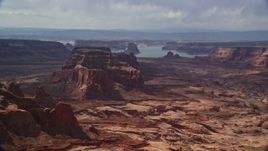 5.5K aerial stock footage of flying by buttes, Lake Powell in the background, Navajo Nation Reservation, Arizona Aerial Stock Footage | AX132_011E