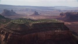 5.5K aerial stock footage of flying by desert mesa with view of distant buttes, Navajo Nation Reservation, Arizona, Utah Aerial Stock Footage | AX132_123