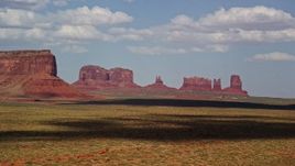 5.5K aerial stock footage of passing four desert buttes in Monument Valley, Arizona, Utah Aerial Stock Footage | AX132_134E