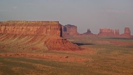 5.5K aerial stock footage of passing by Eagle Mesa, distant buttes, Monument Valley, Utah, Arizona, sunset Aerial Stock Footage | AX133_002E