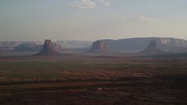 5.5K aerial stock footage of a wide view of buttes, mesas across desert valley, Monument Valley, Utah, Arizona, twilight Aerial Stock Footage | AX133_017E