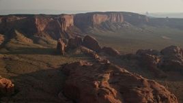 5.5K aerial stock footage of passing by rock formations and Hunt's Mesa, Monument Valley, Utah, Arizona, sunset Aerial Stock Footage | AX133_061E