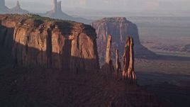5.5K aerial stock footage of flying by Three Sisters and Mitchell Mesa, Monument Valley, Utah, Arizona, twilight Aerial Stock Footage | AX133_069E