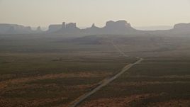 5.5K aerial stock footage of wide view of highway leading to buttes and mesas in Monument Valley, Utah, Arizona, twilight Aerial Stock Footage | AX133_100E