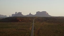 5.5K aerial stock footage of flying toward buttes, following highway in Monument Valley, Utah, Arizona, twilight Aerial Stock Footage | AX133_110E
