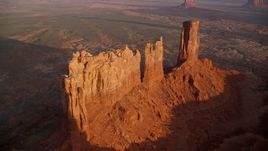 5.5K aerial stock footage of flying away from buttes in Monument Valley, Utah, Arizona, sunset Aerial Stock Footage | AX133_143