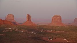 5.5K aerial stock footage of flying past buttes in a desert valley, Monument Valley, Utah, Arizona, sunset Aerial Stock Footage | AX133_164E