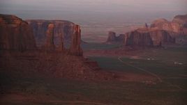 5.5K aerial stock footage of passing by Three Sisters and Rain Got Mesa, Monument Valley, Utah, Arizona, sunset Aerial Stock Footage | AX133_177E