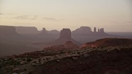 5.5K aerial stock footage of passing by distant buttes through thick haze, Monument Valley, Utah, Arizona, twilight Aerial Stock Footage | AX133_204E