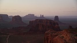 5.5K aerial stock footage pass by buttes in a hazy desert valley, Monument Valley, Utah, Arizona, twilight Aerial Stock Footage | AX133_215E
