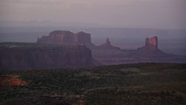 5.5K aerial stock footage of mesas and buttes in the hazy valley, Monument Valley, Utah, Arizona, twilight Aerial Stock Footage | AX133_223E