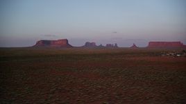 5.5K aerial stock footage of passing buttes between mesas, seen from airport in Monument Valley, Utah, Arizona, twilight Aerial Stock Footage | AX133_234
