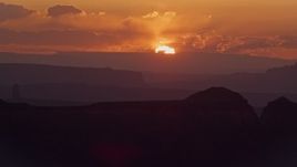 5.5K aerial stock footage of passing by sun setting behind a mesa, Monument Valley, Utah, Arizona, sunset Aerial Stock Footage | AX134_008E