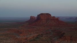 5.5K aerial stock footage of flying by buttes and hazy desert valley, Monument Valley, Utah, Arizona, twilight Aerial Stock Footage | AX134_014E