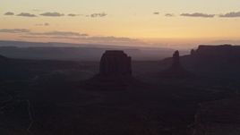 5.5K aerial stock footage of passing by Merrick Butte, West Mitten Butte in Monument Valley, Utah, Arizona, sunset Aerial Stock Footage | AX134_033