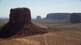 5.5K aerial stock footage of passing Mitchell Butte and Merrick Butte, reveal other buttes in Monument Valley, Utah, Arizona Aerial Stock Footage | AX135_008E
