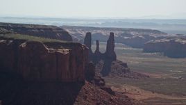 5.5K aerial stock footage of flying by Three Sisters buttes, mesas in Monument Valley, Utah, Arizona Aerial Stock Footage | AX135_014E