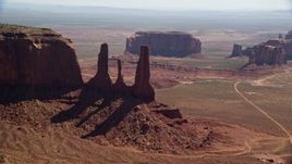 5.5K aerial stock footage of flying by Three Sisters, with buttes in the background, Monument Valley, Utah, Arizona Aerial Stock Footage | AX135_017E