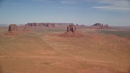 5.5K aerial stock footage of a wide view of several buttes and mesas in a desert valley, Monument Valley, Utah, Arizona Aerial Stock Footage | AX135_034E