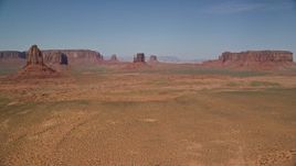 5.5K aerial stock footage of passing several desert buttes and mesas in Monument Valley, Utah, Arizona Aerial Stock Footage | AX135_041E