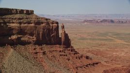 5.5K aerial stock footage of a reverse view of Eagle Rock Butte by Eagle Mesa, Monument Valley, Utah, Arizona Aerial Stock Footage | AX135_054E