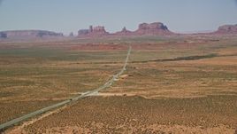 5.5K aerial stock footage of flying over Forrest Gump Point by Highway 163, approach distant buttes in Monument Valley, Utah, Arizona Aerial Stock Footage | AX135_075E