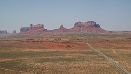 5.5K aerial stock footage of a wide view of Highway 163 leading to desert buttes, Monument Valley, Utah, Arizona Aerial Stock Footage | AX135_079E