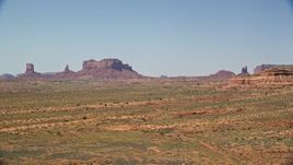 5.5K aerial stock footage of passing distant buttes in an open desert valley, Monument Valley, Utah, Arizona Aerial Stock Footage | AX135_085